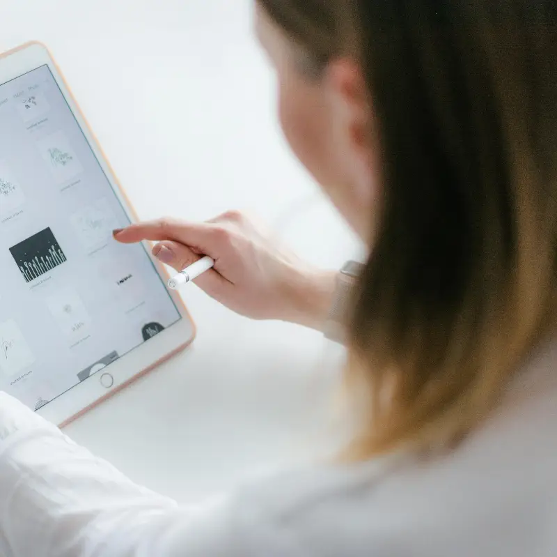 A woman interacts with a tablet to create digital art. Ideal for technology and creativity concepts.