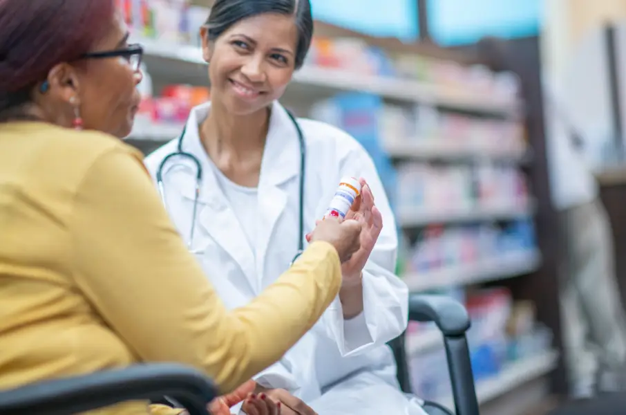 Pharmacist handing a pill bottle to a patient